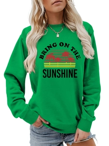 Detail of green crewneck sweatshirt featuring a retro sun and palm tree graphic print