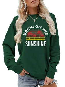 Detail of dark green sweatshirt featuring Bring On The Sunshine graphic with palm trees