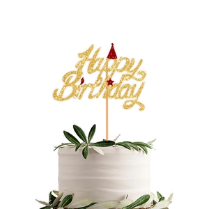 Detail of gold glitter Happy Birthday cake topper with red hat and star on white cake