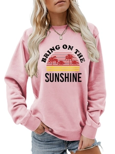 Detailed close-up of 'BRING ON THE SUNSHINE' sunset print on pink crewneck sweatshirt