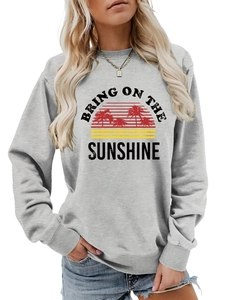 Detail of grey crewneck sweatshirt featuring Bring on the Sunshine tropical sunset print