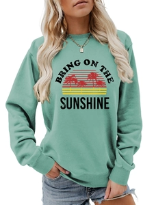 Detail of mint green sweatshirt with retro sun and palm tree print and slogan