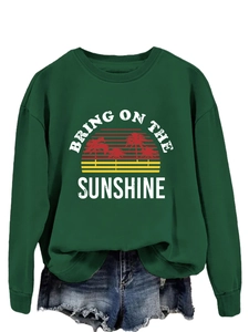 Close-up of the vintage palm tree print and Bring On The Sunshine text on green sweatshirt