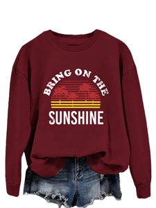 Detail of burgundy sweatshirt with Bring on the Sunshine palm tree sunset graphic print
