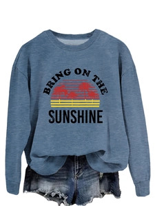 Close-up of Bring On The Sunshine graphic print on blue crewneck sweatshirt fabric