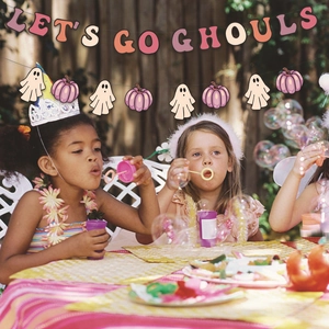 Kids celebrating Halloween with pink pumpkin banners and Let's Go Ghouls party bunting