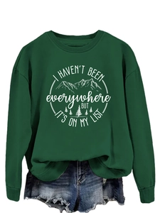 Close-up of ribbed crewneck and mountain print on this dark green fashion sweatshirt