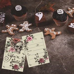 Gothic Halloween party invitation cards with skull and rose motifs on dark stone background