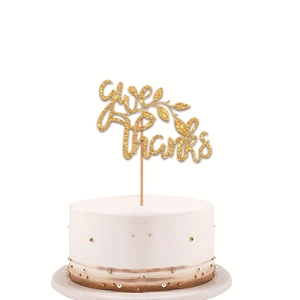Glittery gold Give thanks cake topper with leaf design on a white cream cake