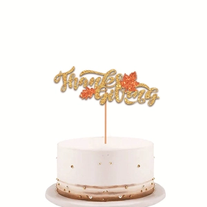 Glittering gold Thanksgiving cake topper with orange maple leaves on a white cake