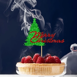 Close-up of green glitter Christmas tree cake topper with Merry Christmas text on fruit tart