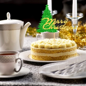 Glittery green Christmas tree cake topper with gold Merry Christmas text on a cream cake
