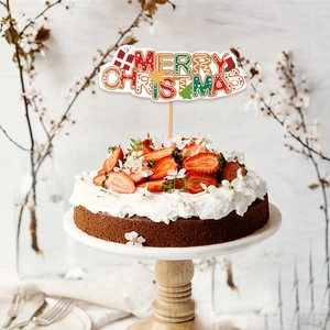 Merry Christmas cake topper with festive tree and gift icons on a fresh cream cake