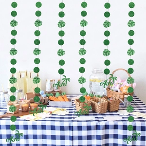 Glittery Aloha banner with tropical monstera leaves and green discs for party decor