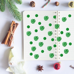 Tropical monstera leaf and green circle glitter confetti on a spiral notebook page