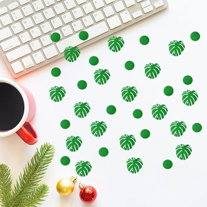 Green glitter Monstera and round confetti set on desk with coffee and holiday decor