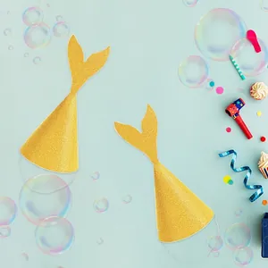 Close-up of golden sequin mermaid tail party hats with elastic bands on a blue backdrop