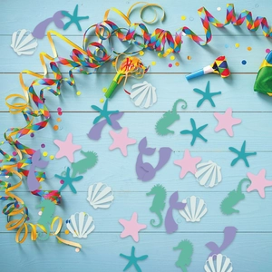 Ocean theme party confetti featuring mermaid tails shells and seahorses on blue wood