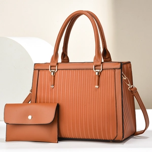 Détail du sac à main caramel avec rayures verticales et pochette assortie sur support blanc