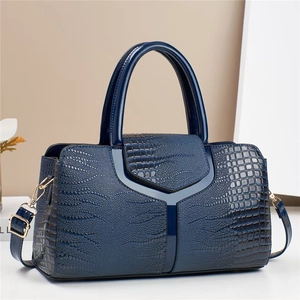 Détail du sac à main bleu foncé en similicuir gaufré avec texture croco et détails dorés