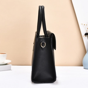 Dettaglio borsa tote in pelle nera con finiture dorate e anello a D laterale
