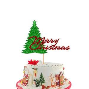 Macro detail of Merry Christmas glitter cake topper with green tree on white festive cake