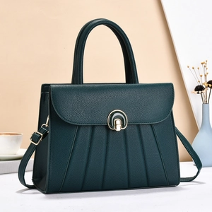 Dettaglio della borsa in pelle verde scuro con design a pieghe e fibbia oro