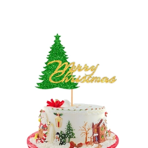 Close-up of a glittery green Christmas tree cake topper with gold Merry Christmas text