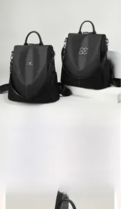 Vue détaillée de sacs à dos noirs en nylon avec logo métallique argenté et poignée en cuir