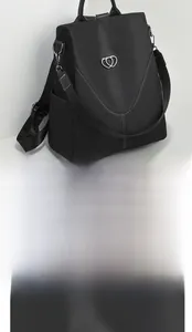 Détail du tissu en nylon noir résistant à l'eau et boucle en cœur sur un sac à dos