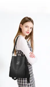 Détail d'un sac à dos noir avec coutures contrastées et logo argenté pour femme