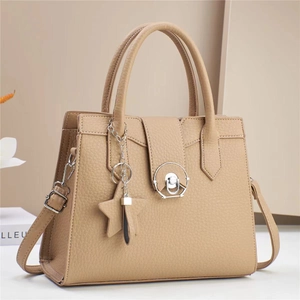 Beige pebbled leather handbag with round metal buckle and star charm accessory