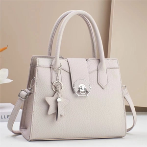Minimalist beige pebble leather tote bag with silver hardware and star charm accessory