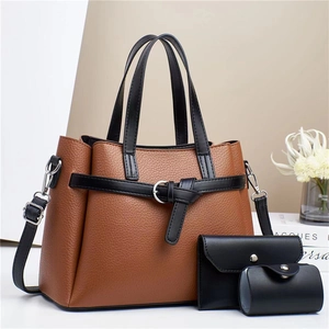 Detailed view of brown litchi grain tote bag with black strap and matching accessories