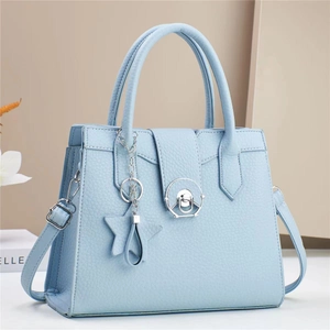 Close-up of sky blue lychee grain leather handbag with silver ring twist lock and star charm