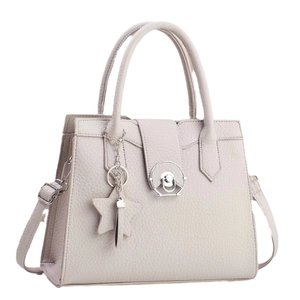 Minimalist beige pebble leather tote bag with circular metal lock and star charm detail