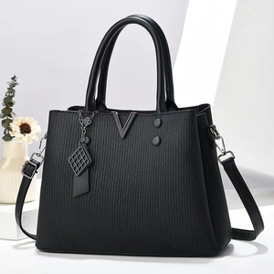 Dettaglio della borsa tote in PU nero con trama verticale e decorazioni metalliche a V