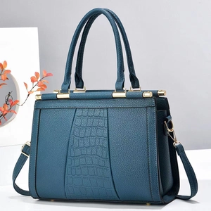 Close-up of navy blue faux leather tote with lychee and crocodile texture and gold hardware