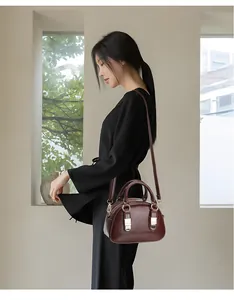 Deep red vintage Boston bag detail with smooth oil wax leather finish and gold metal accents