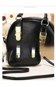 Detail view of glossy black leather texture with gold hardware and adjustable strap