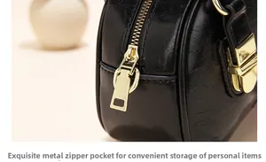 Detail of high-gloss gold metal zipper on minimalist black oil-waxed leather handbag