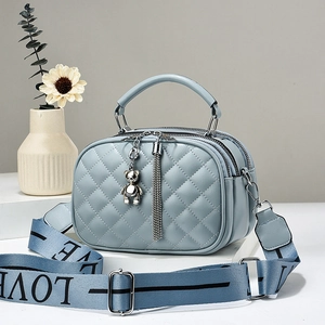 Sac bandoulière matelassé bleu clair avec double zip et pendentif ours
