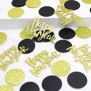 Macro shot of gold glitter Happy New Year confetti and black dots for party decor