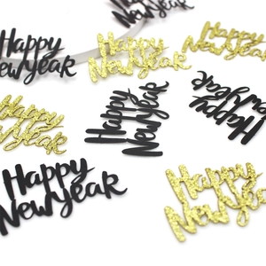 Detail of Happy New Year confetti in matte black and gold glitter for party decoration
