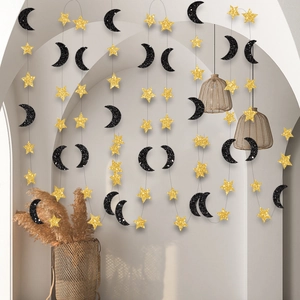 Détail de guirlande d'étoiles dorées et lunes noires pailletées pour décoration de fête