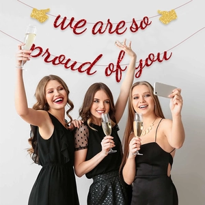 Red glitter 'We are so proud of you' graduation banner with gold accents for party decor