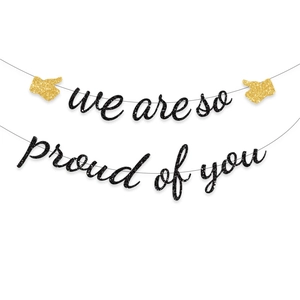 Detail of glittery we are so proud of you banner with gold thumbs up icons for graduation