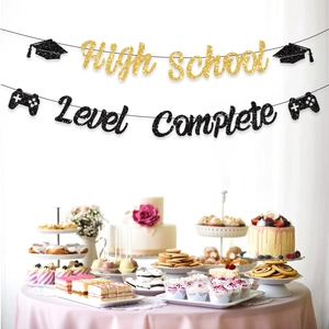 Banderole de remise des diplômes Level Complete noir et or suspendue sur un buffet