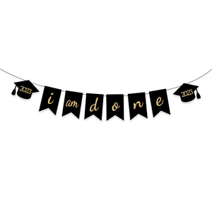 Detail of 2026 graduation banner with gold glitter I Am Done text and black doctoral caps
