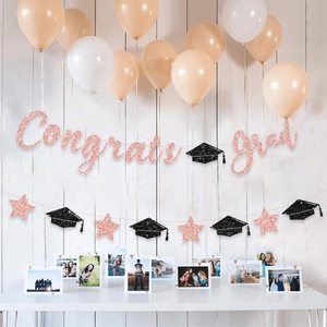 Detail view of rose gold glitter Congrats Grad banner with black graduation cap garland décor